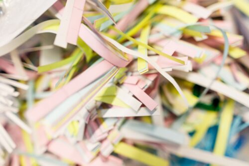 Pile of shredded paper in various colours that will have been sourced responsibly as part of the rise of sustainable practices in the printing industry.